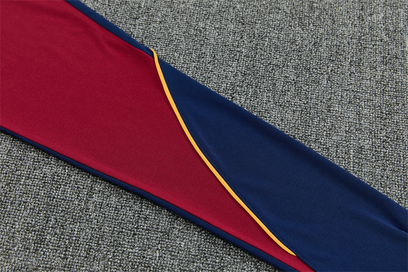 Detalle de la manga azul y granate del chándal Barcelona 26-27 con ribete amarillo en curva