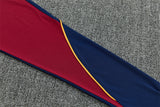 Detalle de la manga azul y granate del chándal Barcelona 26-27 con ribete amarillo en curva