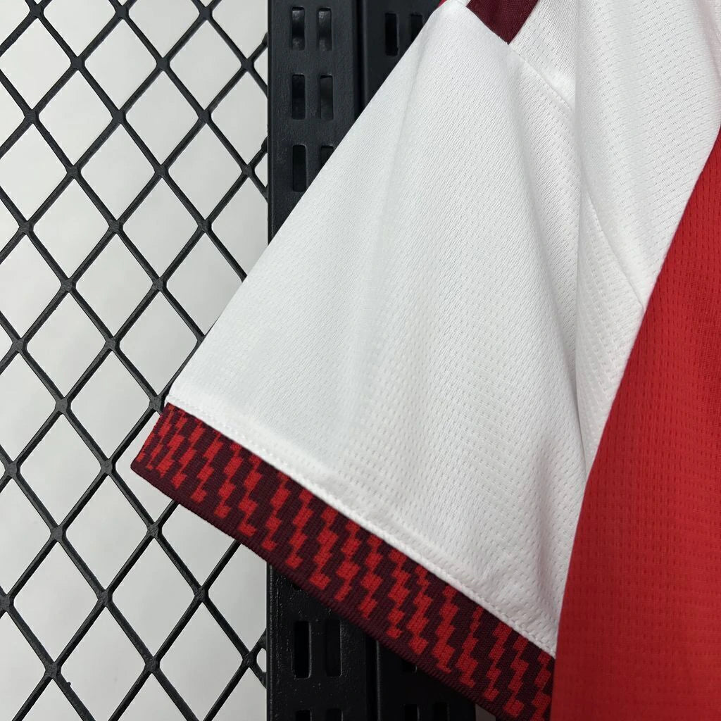 Detalle de la manga blanca y el puño texturizado rojo y granate de la camiseta Arsenal 26-27 local