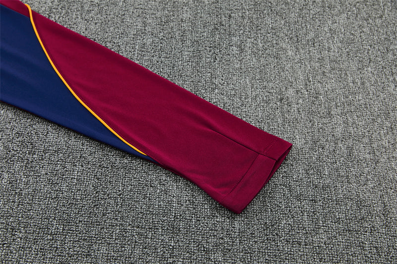 Detalle de la manga granate y azul del chándal Barcelona 26-27 con ribete amarillo en curva