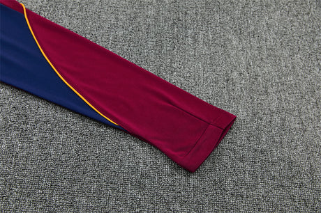 Detalle de la manga granate y azul del chándal Barcelona 26-27 con ribete amarillo en curva