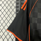 Detalle de la manga negra con ribete naranja y costura lateral de la camiseta Como 25-26 tercera equipación