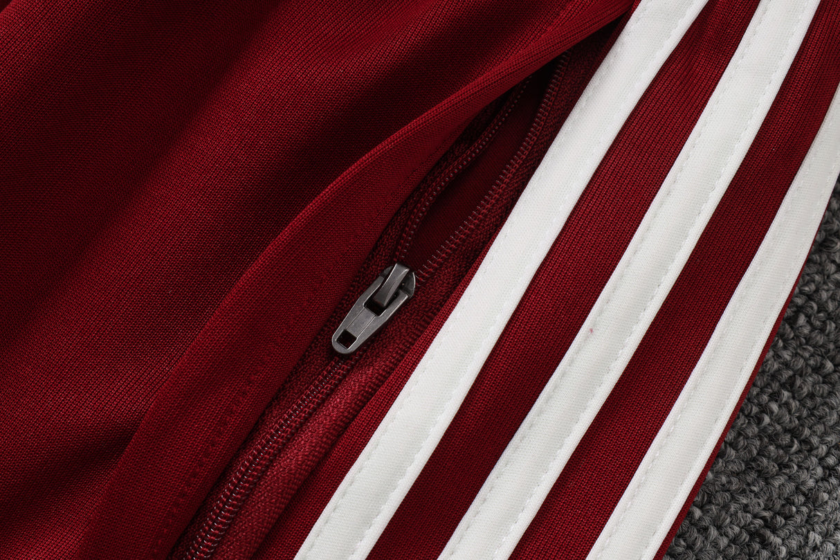 Detalle del bolsillo con cremallera y franjas blancas del pantalón granate del chándal España 26-27 Modelo 2