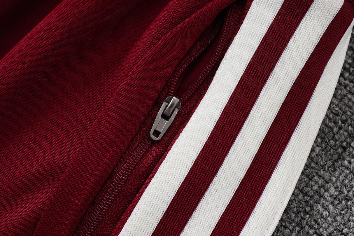 Detalle del bolsillo con cremallera y franjas blancas laterales del pantalón granate del chándal España 26-27 Modelo 1