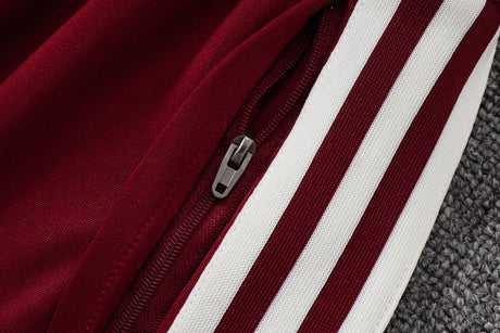 Detalle del bolsillo con cremallera y franjas blancas laterales del pantalón granate del chándal España 26-27 Modelo 1