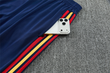 Detalle del bolsillo del pantalón azul marino del Chándal España 26-27 con franjas rojas y amarillas