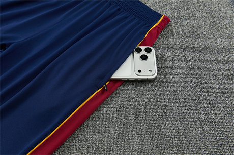 Detalle del bolsillo lateral con cremallera del pantalón azul del chándal Barcelona 26-27 con panel granate y ribete amarillo