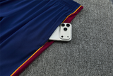 Detalle del bolsillo lateral con cremallera del pantalón azul del chándal Barcelona 26-27 con panel granate y ribete amarillo