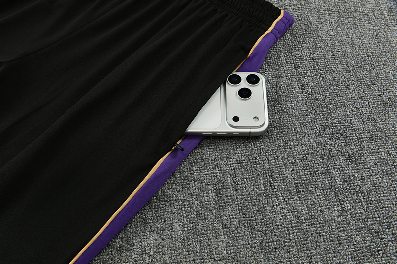 Detalle del bolsillo lateral con cremallera del pantalón negro del chándal Barcelona 26-27 con inserto morado