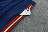 Detalle del bolsillo lateral del pantalón azul marino del Chándal España 26-27 con franjas rojas y amarillas