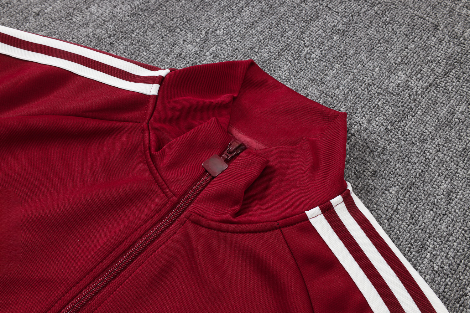 Detalle del cuello alto, cremallera completa y franjas blancas en los hombros del chándal España 26-27 Modelo 1