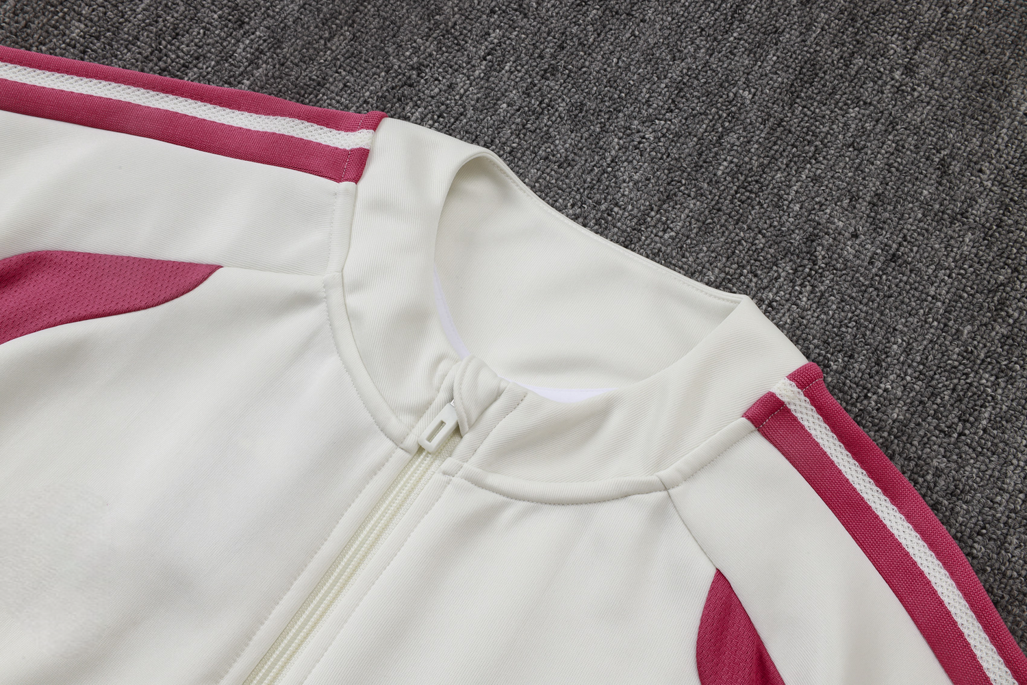 Detalle del cuello alto, la cremallera frontal y las franjas rosas de la chaqueta del chándal R.M. 26-27 modelo 5
