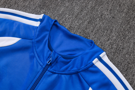 Detalle del cuello alto y la cremallera completa de la chaqueta del chándal Juventus 26-27 con franjas blancas en los hombros