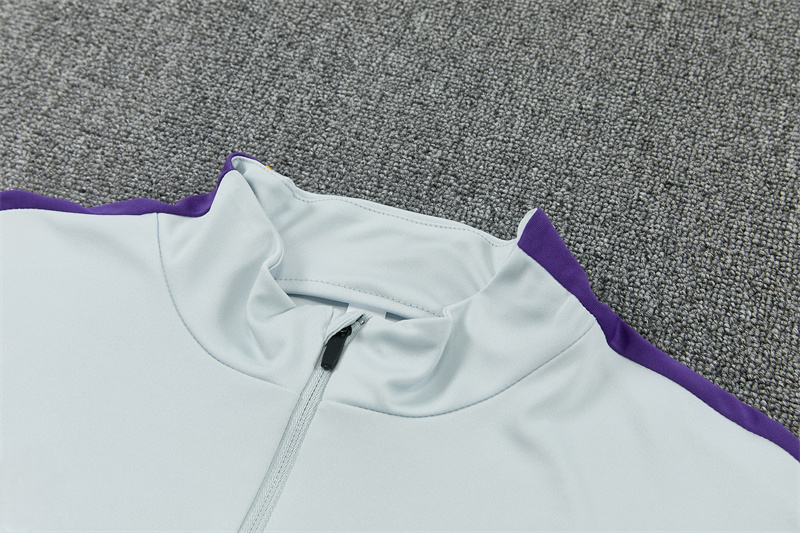 Detalle del cuello alto y la media cremallera del chándal Barcelona 26-27 Modelo 1 con franja morada en el hombro