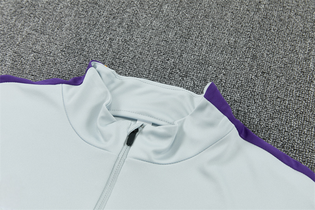 Detalle del cuello alto y la media cremallera del chándal Barcelona 26-27 Modelo 1 con franja morada en el hombro