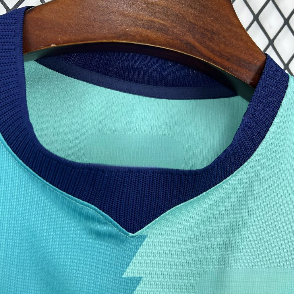 Detalle del cuello de la camiseta Barcelona 26-27 tercera equipación con abertura en V azul marino y tejido verde agua