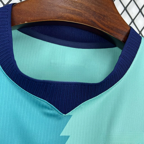 Detalle del cuello de la camiseta Barcelona 26-27 tercera equipación con abertura en V azul marino y tejido verde agua