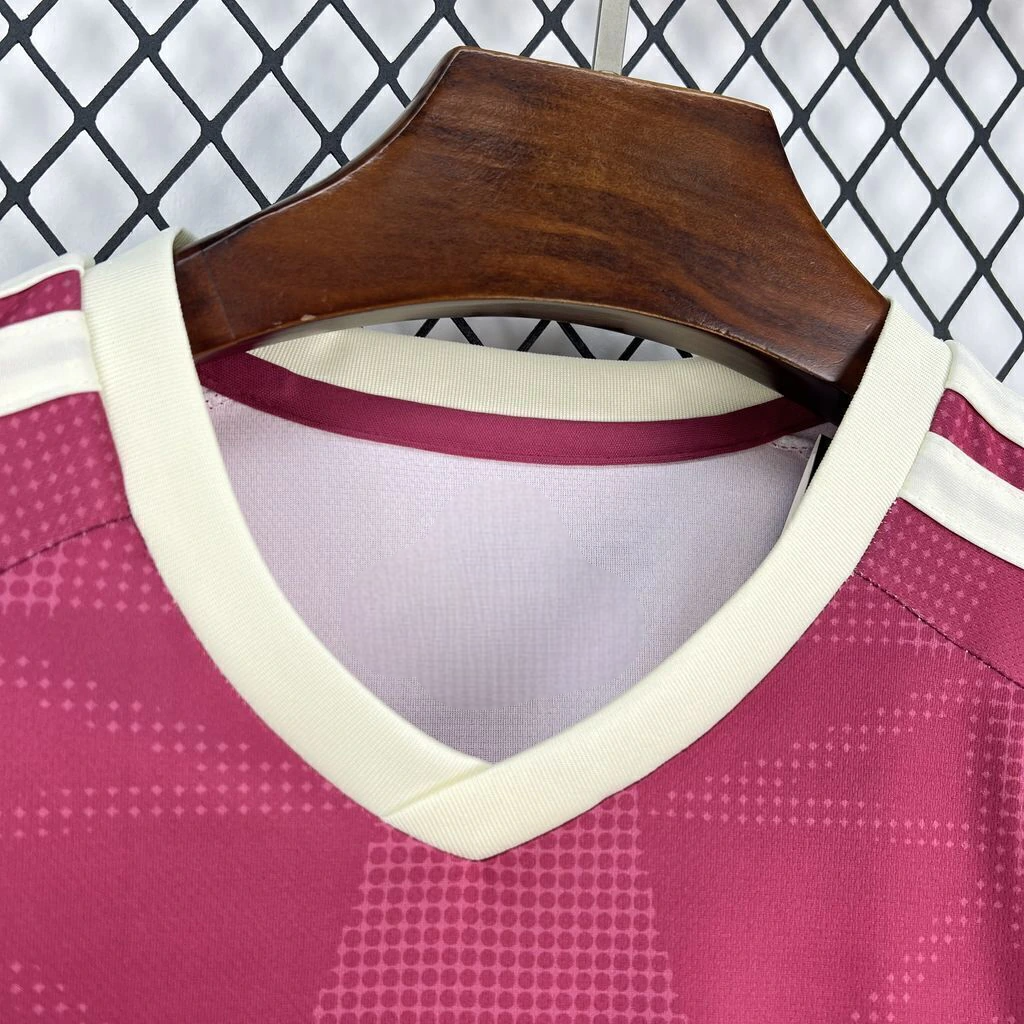 Detalle del cuello en V crema de la camiseta R.M. 26-27 tercera equipación con tejido rosa oscuro y patrón tonal