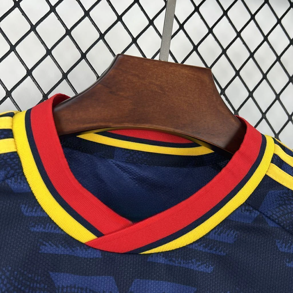 Detalle del cuello en pico de la camiseta Arsenal 26-27 visitante con acabados rojo, amarillo y azul marino