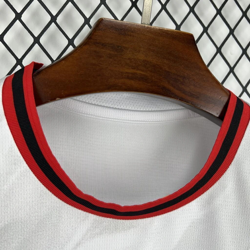 Detalle del cuello redondo de la camiseta AC Milan 26-27 visitante, con ribete de franjas rojas y negras