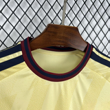 Detalle del cuello redondo de la camiseta Arsenal 26-27 tercera equipación con acabados granate y azul marino sobre tejido amarillo