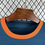 Detalle del cuello redondo naranja de la camiseta Valencia 26-27 visitante y del tejido azul oscuro microperforado