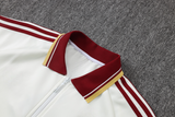 Detalle del cuello tipo polo granate y dorado y franjas de la manga del chándal España 26-27 Modelo 2