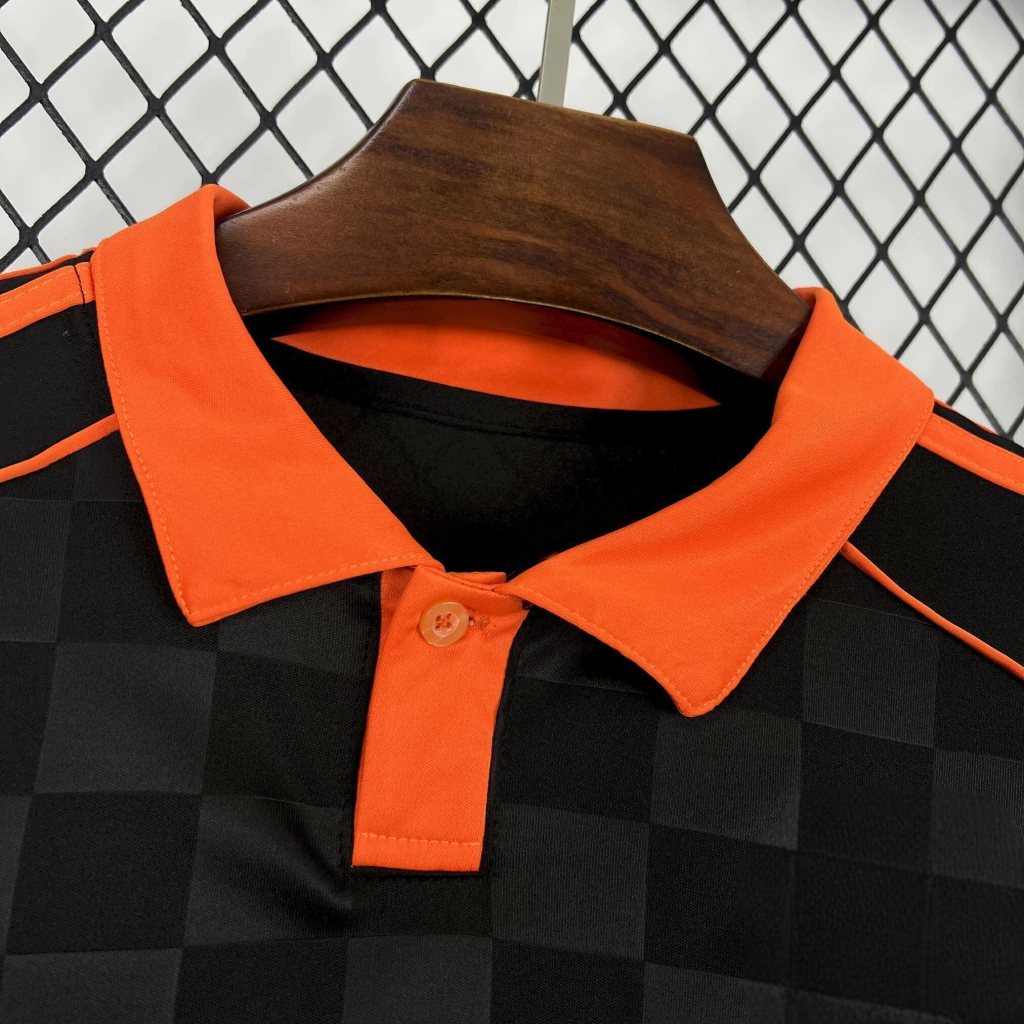 Detalle del cuello tipo polo naranja y cierre con botón de la camiseta Como 25-26 tercera equipación