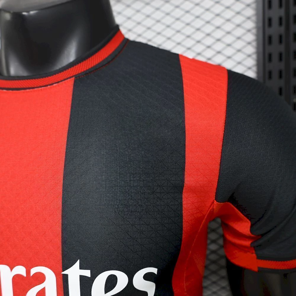 Detalle del hombro, cuello y tejido geométrico de la camiseta AC Milan 26-27 local versión Player en rojo y negro