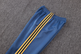 Detalle del pantalón azul del chándal Arsenal 26-27 Modelo 2 con cintura elástica, bolsillo lateral y franjas amarillas