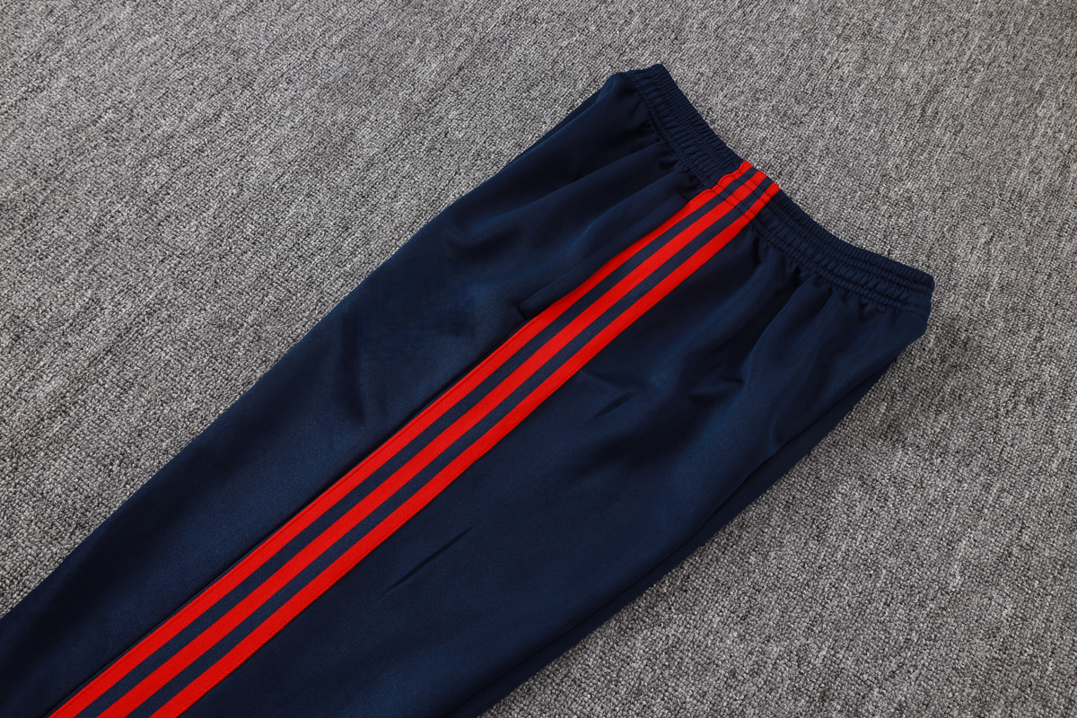 Detalle del pantalón azul marino del chándal Arsenal 26-27 Modelo 1 con cintura elástica y franjas laterales rojas