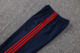 Detalle del pantalón azul marino del chándal Arsenal 26-27 Modelo 1 con cintura elástica y franjas laterales rojas