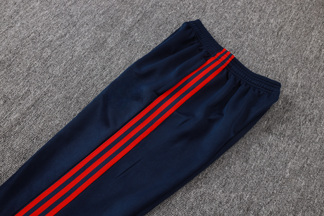 Detalle del pantalón azul marino del chándal Arsenal 26-27 Modelo 1 con cintura elástica y franjas laterales rojas