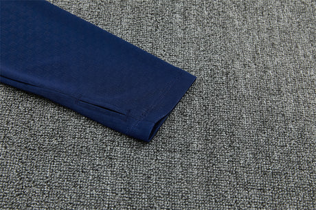 Detalle del puño azul marino de la manga del Chándal España 26-27 media cremallera