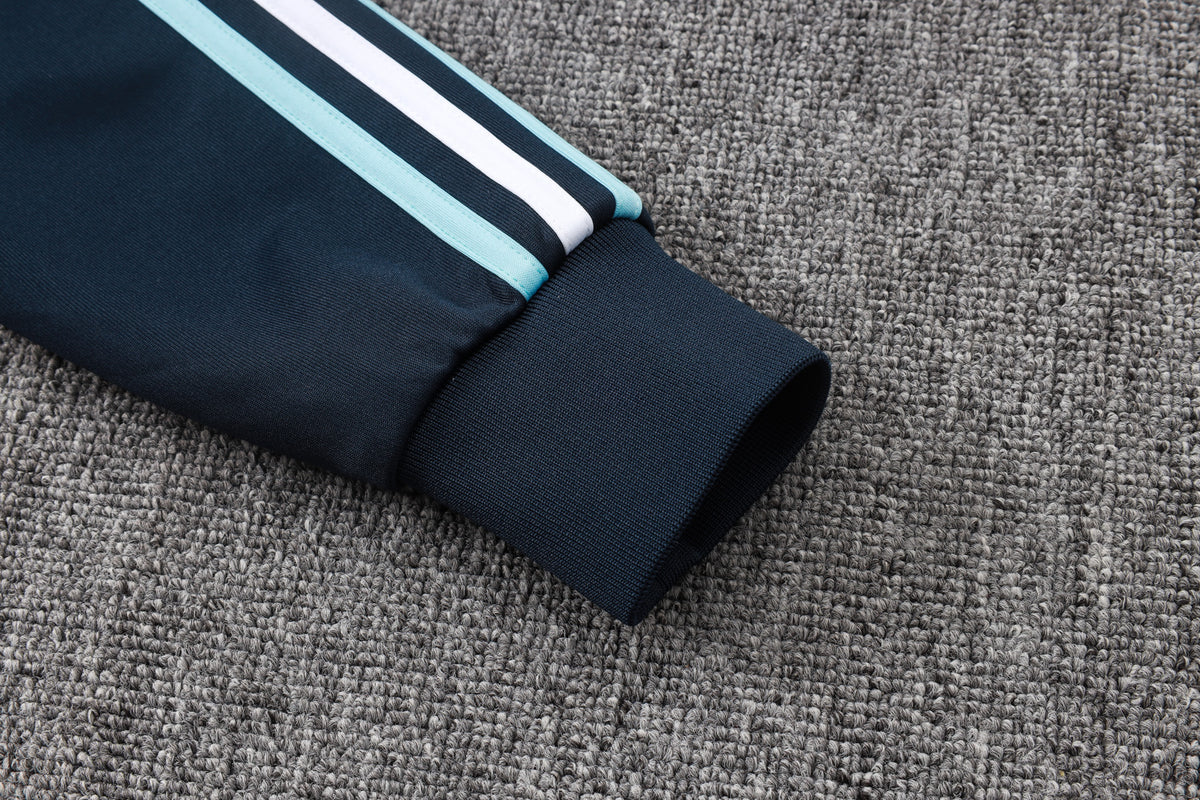 Detalle del puño de la manga con franjas azul celeste y blanca de la chaqueta del chándal Argentina 26-27 Modelo 1