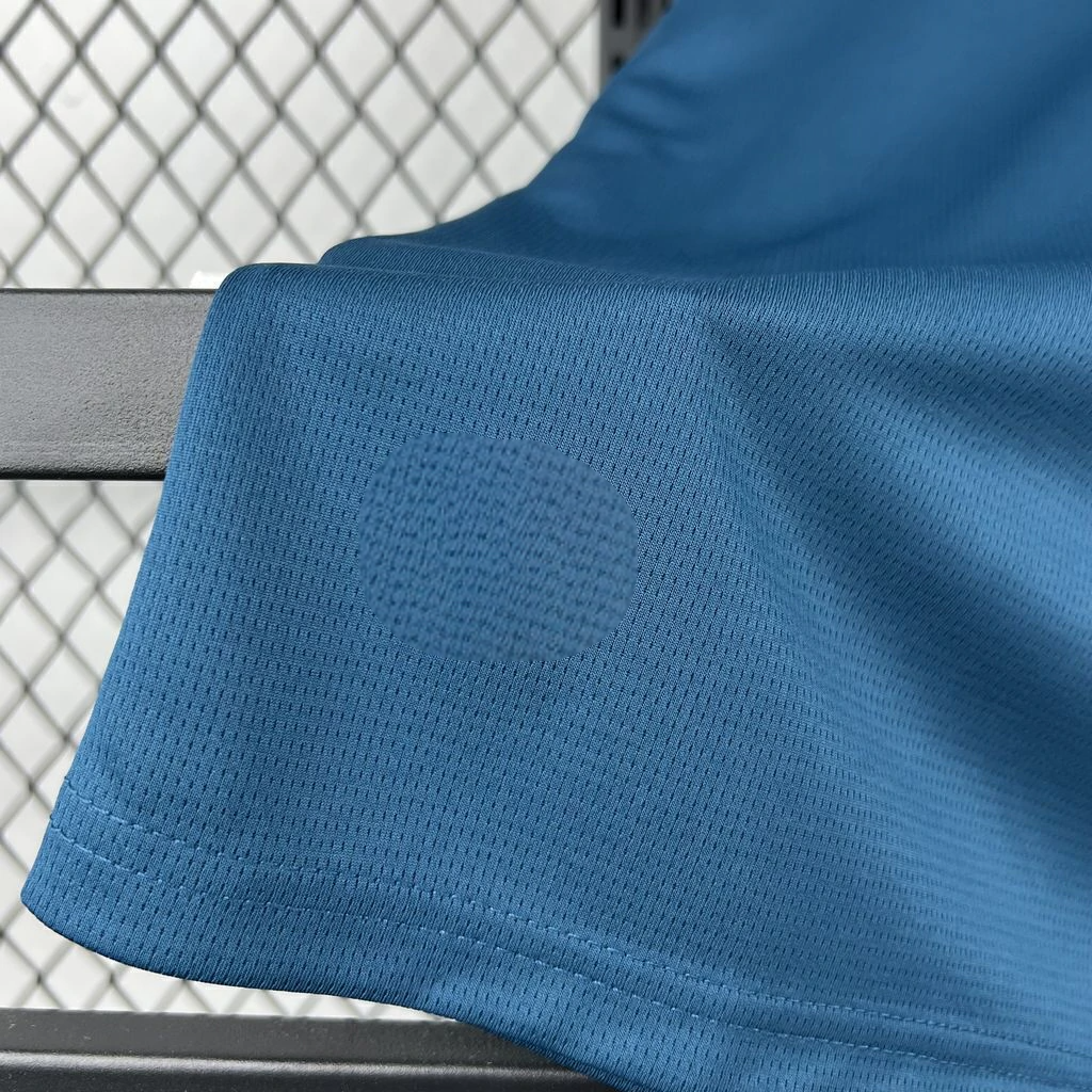 Detalle del tejido azul microperforado y el dobladillo cosido de la camiseta Valencia 26-27 visitante