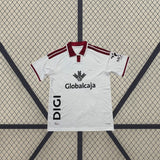 Detalle frontal de la camiseta Albacete 26-27 local blanca con cuello tipo polo granate, franjas en los hombros y manga corta
