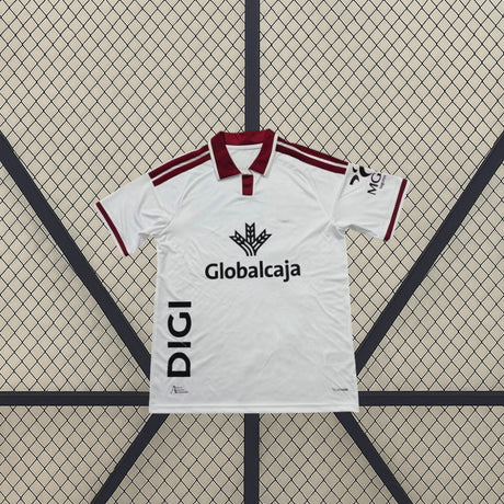 Detalle frontal de la camiseta Albacete 26-27 local blanca con cuello tipo polo granate, franjas en los hombros y manga corta
