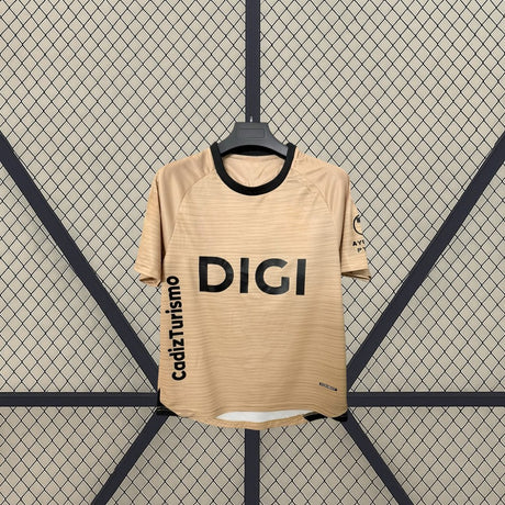 Detalle frontal de la camiseta Cádiz 26-27 tercera equipación con cuello redondo negro, tejido beige de líneas finas y manga corta