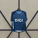 Detalle frontal de la camiseta Cádiz 26-27 visitante con patrón tonal azul, cuello redondo celeste y paneles oscuros en los hombros