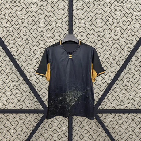 Detalle frontal de la camiseta Córdoba 26-27 Visitante negra y dorada con gráfico cartográfico inferior y cuello con abertura central