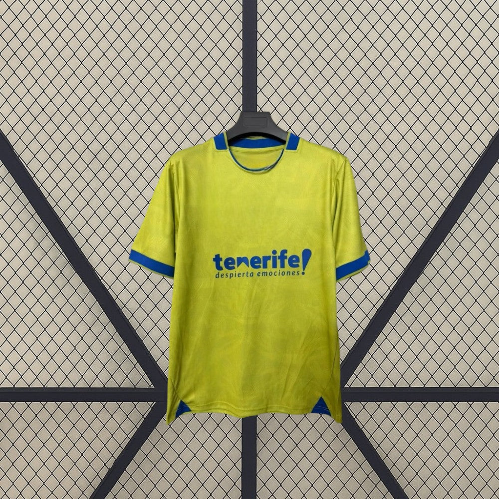 Detalle frontal de la camiseta Tenerife 26-27 tercera equipación con base amarillo lima, remates azules y tejido con patrón sutil