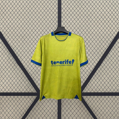 Detalle frontal de la camiseta Tenerife 26-27 tercera equipación con base amarillo lima, remates azules y tejido con patrón sutil