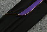 Detalle lateral del pantalón negro del chándal Barcelona 26-27 con panel morado y ribete dorado