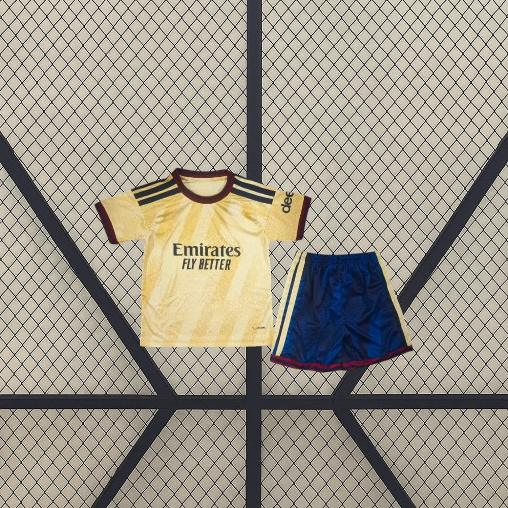 Equipación Arsenal 26-27 tercera niño vista frontal con camiseta amarilla de patrón tonal y pantalón azul marino con bandas amarillas