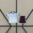 Equipación Aston Villa 26-27 tercera niño vista frontal con camiseta azul celeste de patrón tonal y pantalón corto granate con franjas azul celeste