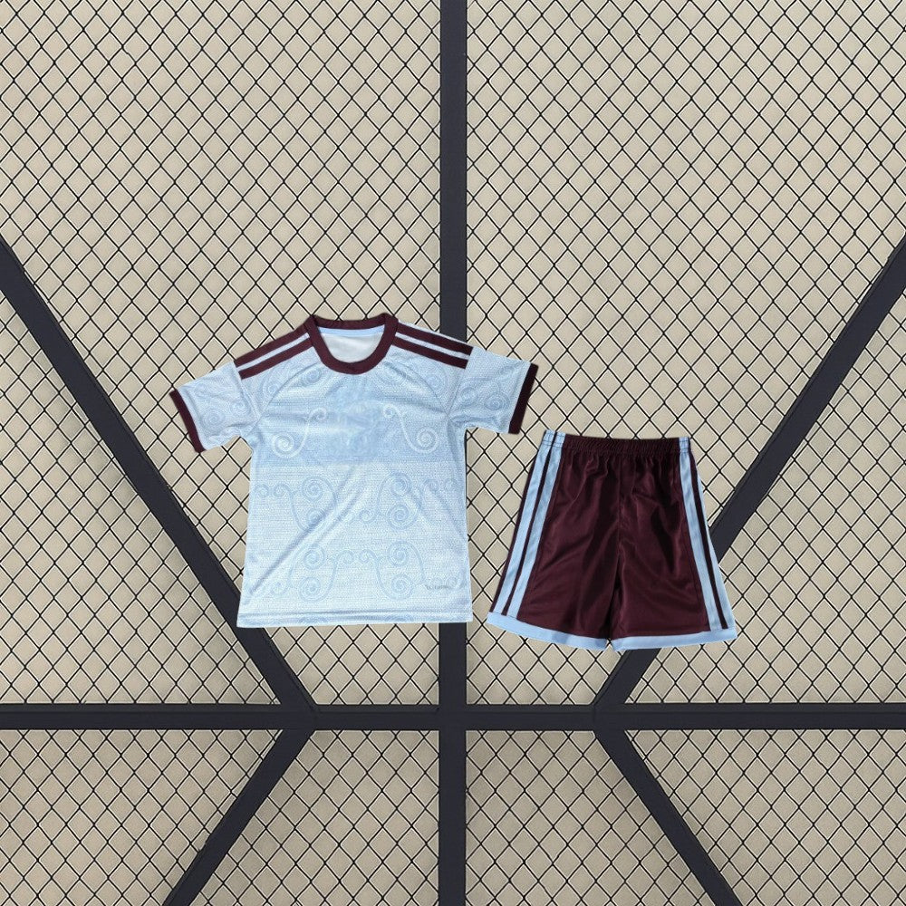 Equipación Aston Villa 26-27 tercera niño vista frontal con camiseta azul celeste de patrón tonal y pantalón corto granate con franjas azul celeste