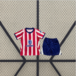 Equipación Atlético de Madrid 26-27 local para niño con camiseta de franjas rojas y blancas y pantalón corto azul marino