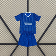 Equipación Brighton 26-27 Local de niño con camiseta azul de líneas verticales blancas, cuello en V y pantalón azul