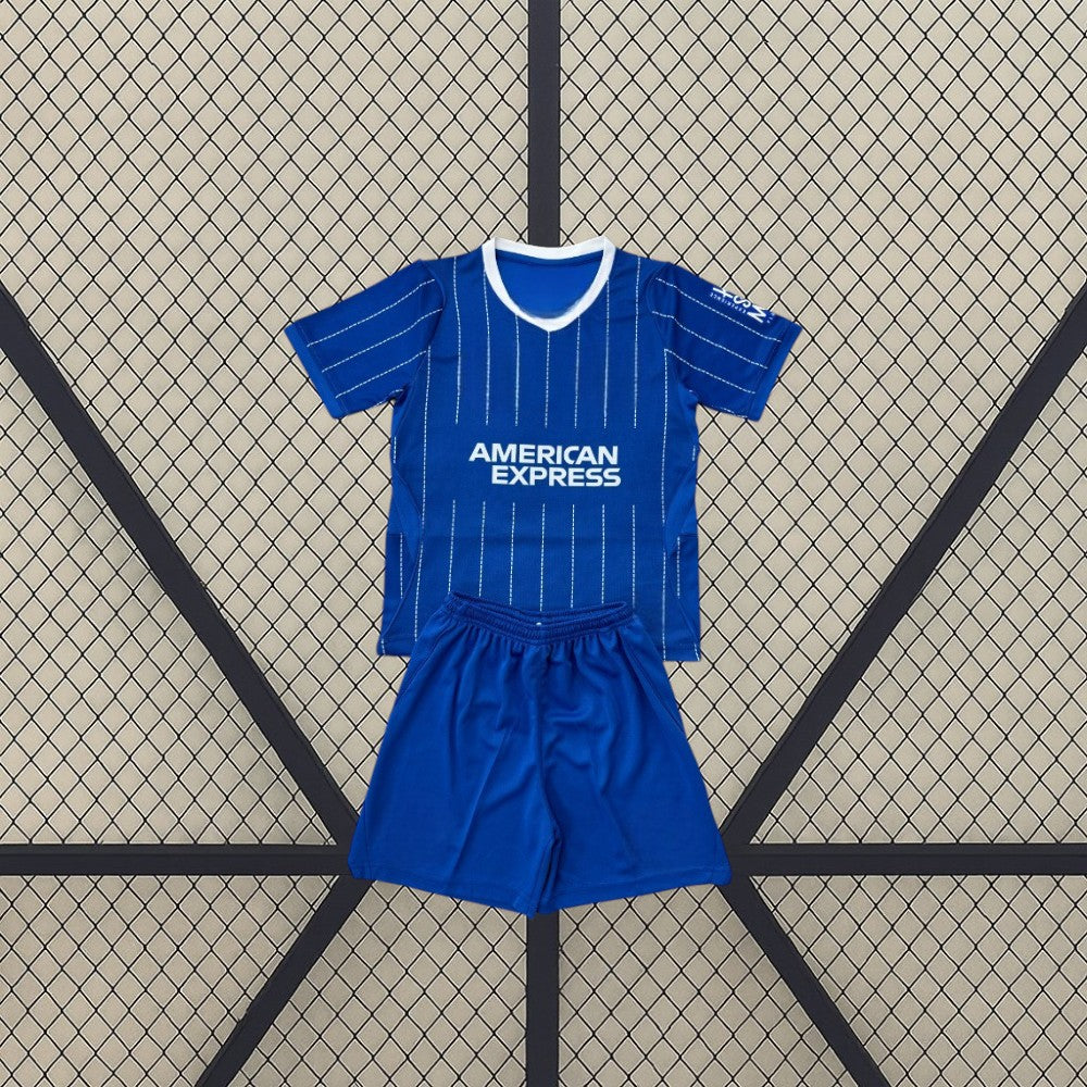 Equipación Brighton 26-27 Local de niño con camiseta azul de líneas verticales blancas, cuello en V y pantalón azul